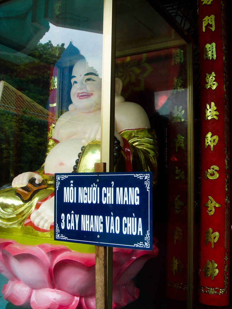 A happy Buddha enclosed in a glass case