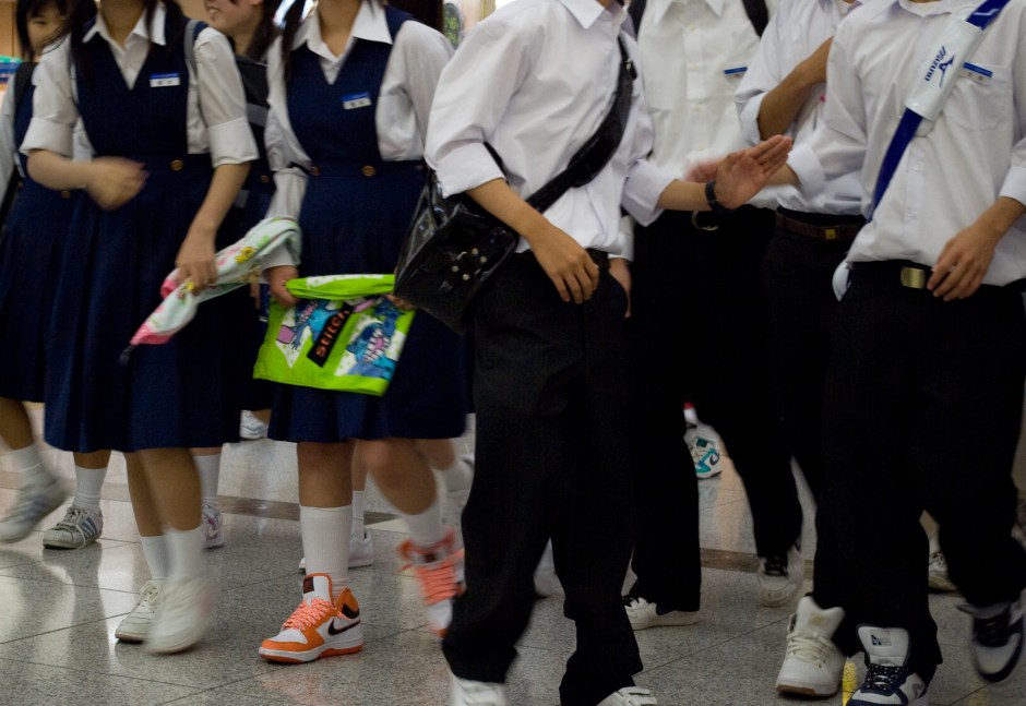 A group of school children migrate through a subway station in Osaka