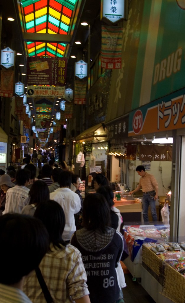 Shoppers crowd the dark alleys of a popular market in Kyoto