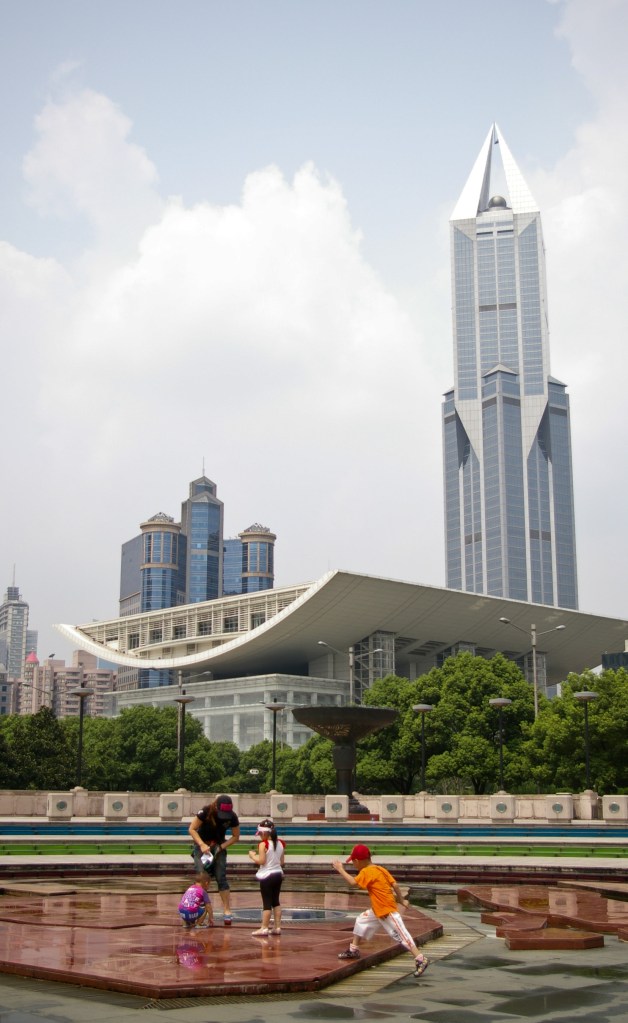 A family plays in the fountains at Century Park in Shanghai