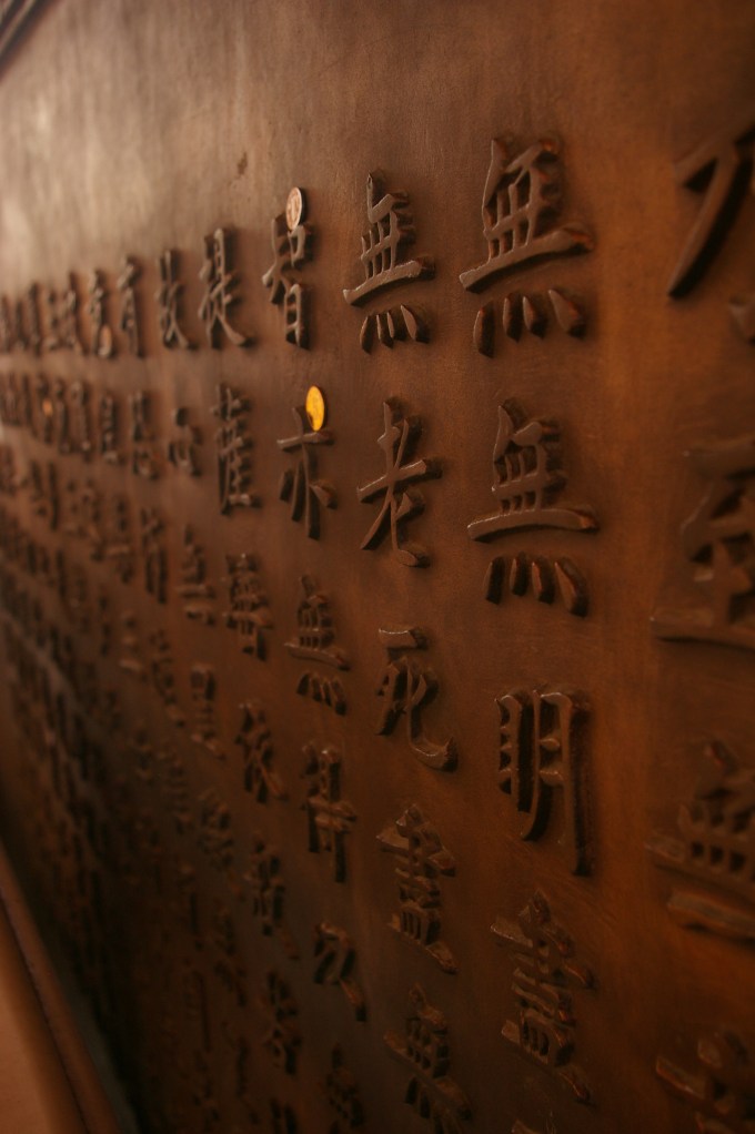 Coins left for luck among the script at Jing'an Temple