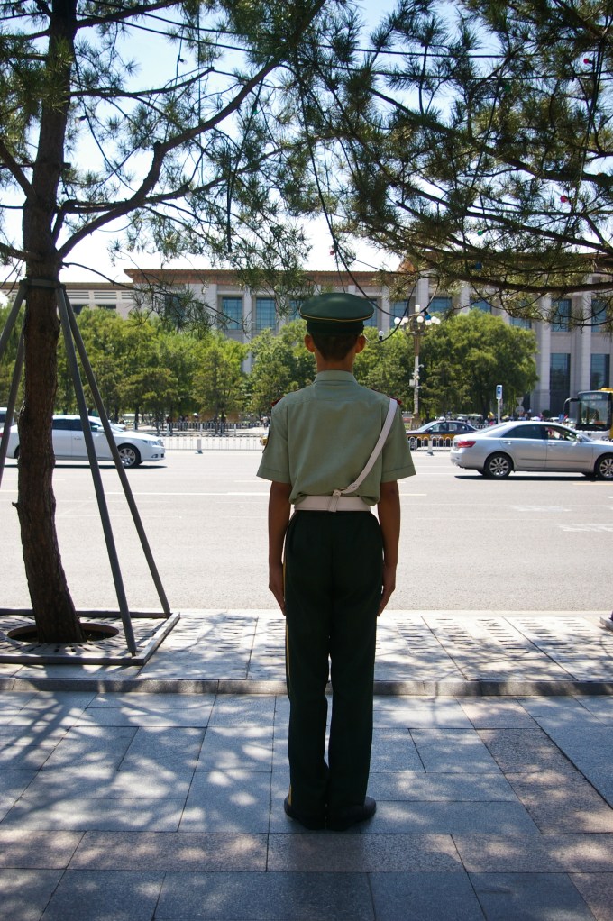 A young police officer stands at his post