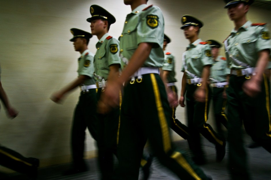 Young police officers march through a subway station in China