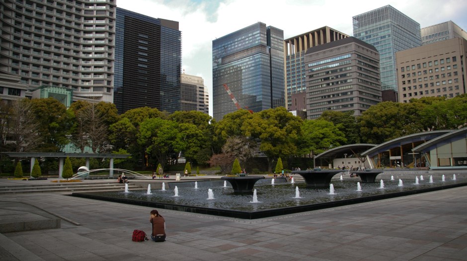 A woman sits alone in the Kokyo Gaien National Garden