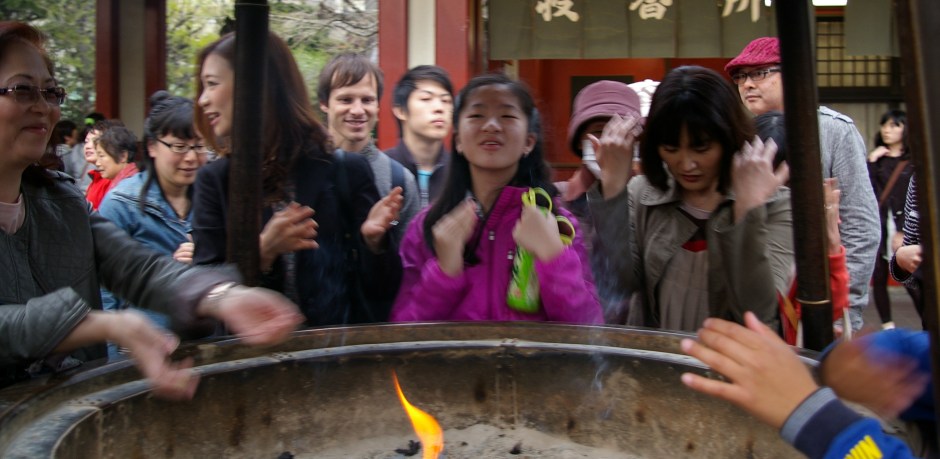 A young girl bathes herself in smoke at the Senso-ji Temple