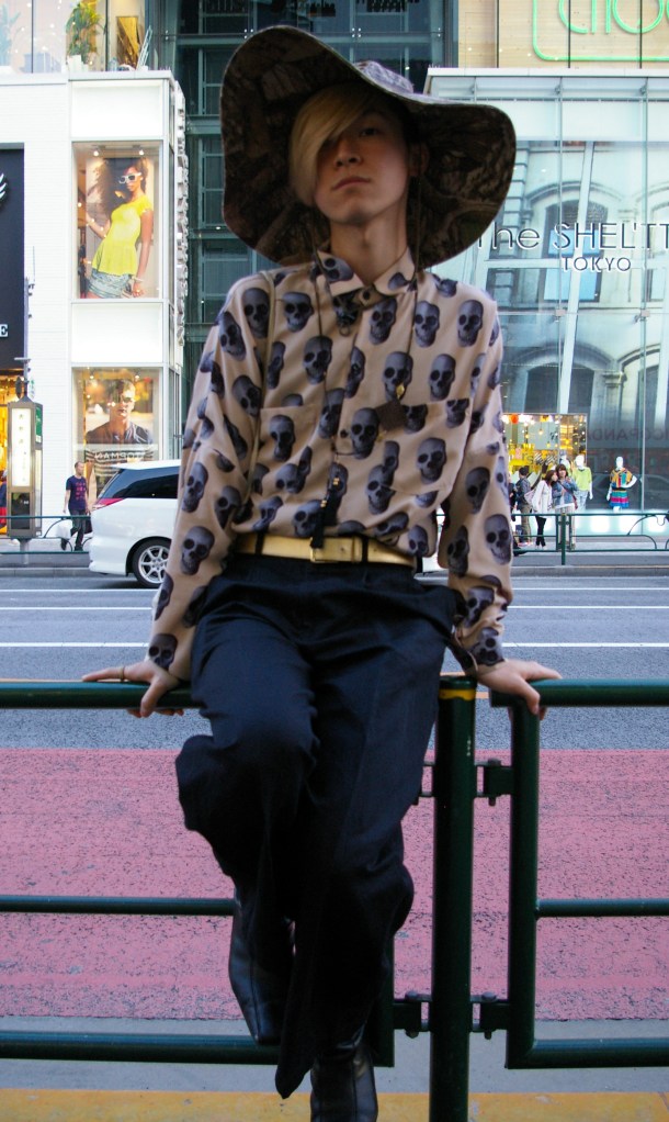 A young man poses for passersby in Harajuku